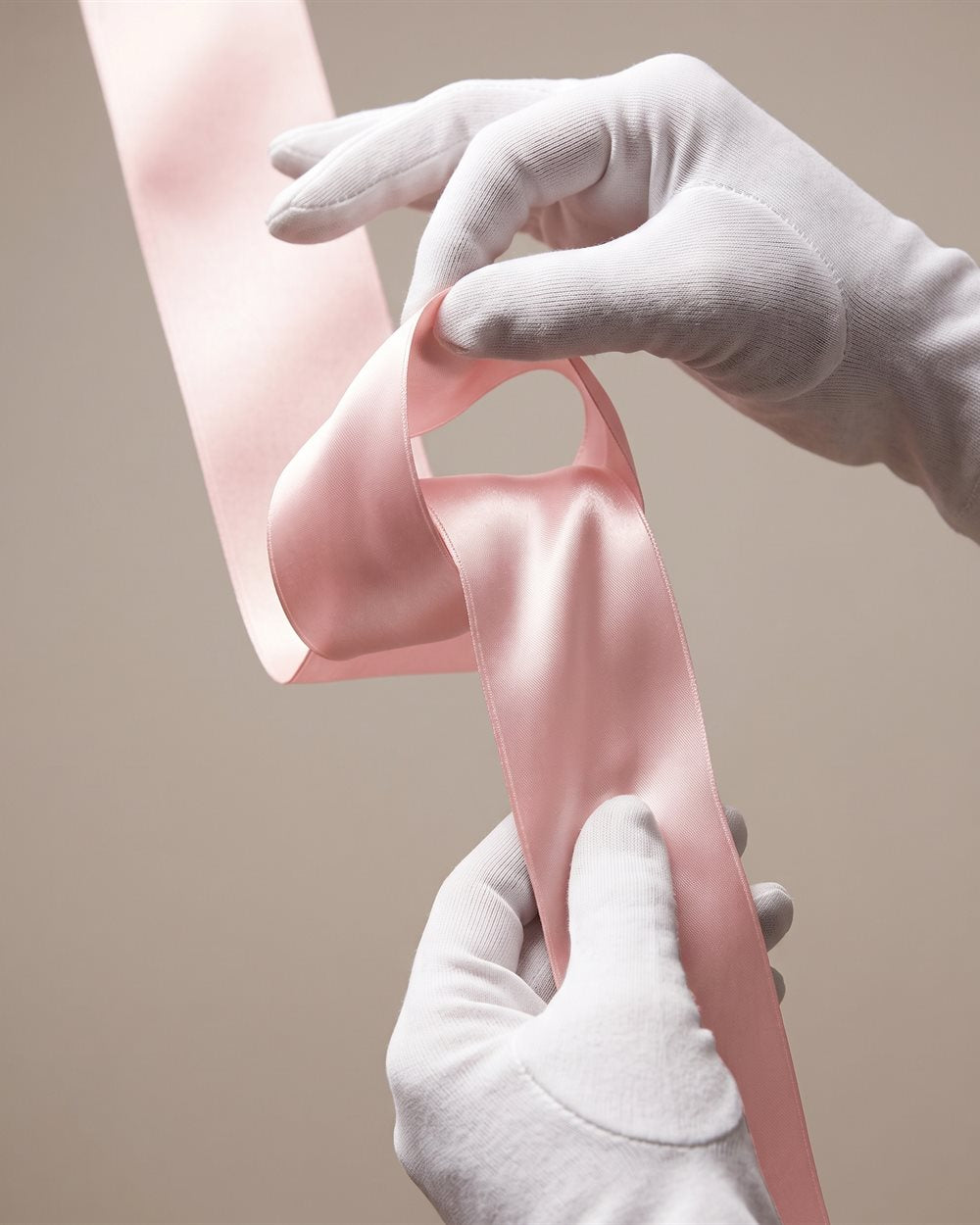 Macro of a strip of blush satin, its sheen following the fold